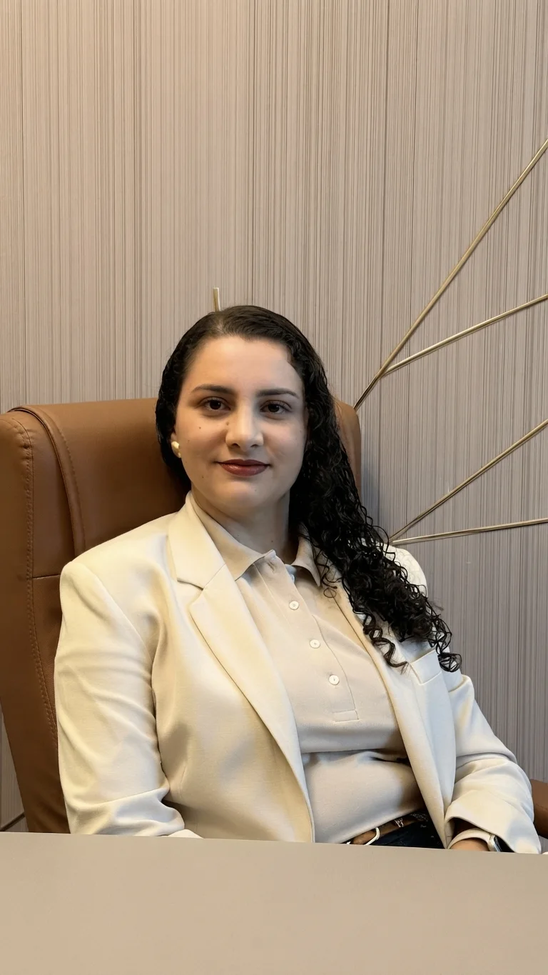 Dra. Paula Thais Bandeira Elias, neurologista e neurologista infantil em Conselheiro Lafaiete, sentada na poltrona do consultório